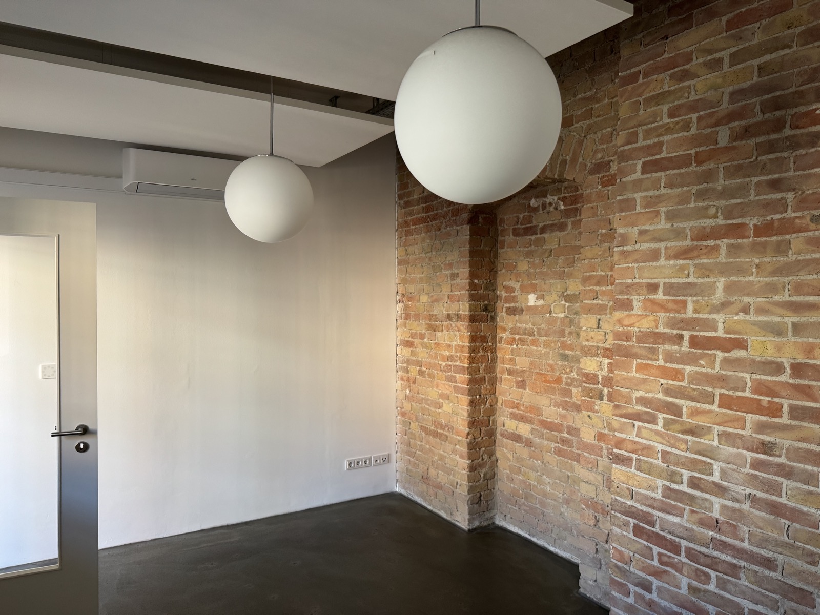 Moderne Kugellampen vor Backsteinwand